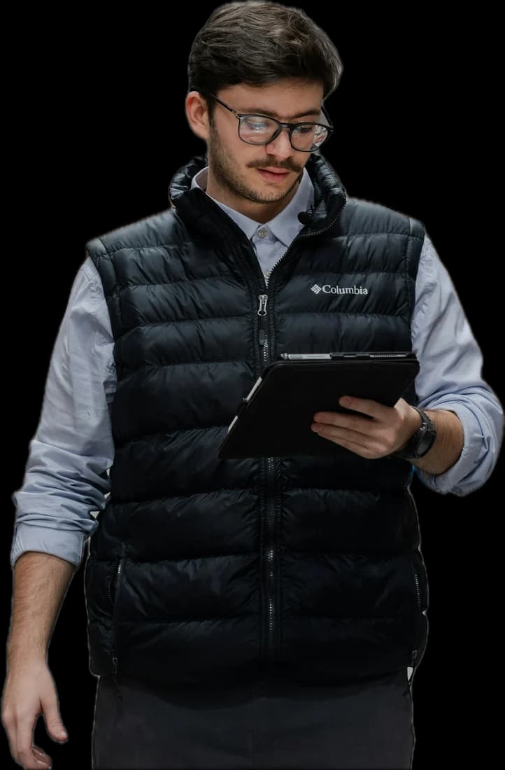 A warehouse manager reading a tablet as he walks